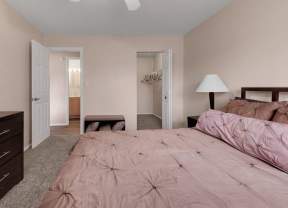 a bedroom with a bed and a dresser and a closet at St Charles Square Apartments, Carol Stream, IL, 60188