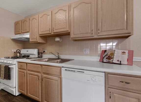 a kitchen with white appliances and wooden cabinets at St Charles Square Apartments, Carol Stream
