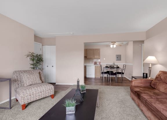 a living room with a leather couch and a coffee table at St Charles Square Apartments, Carol Stream, IL