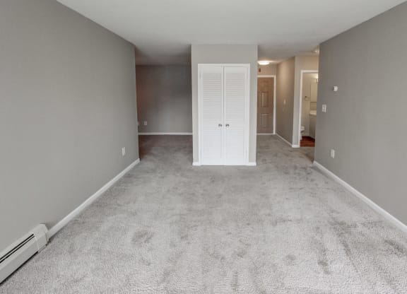 an empty living room with white carpet and a white door at Stepny Place, Rocky Hill, CT