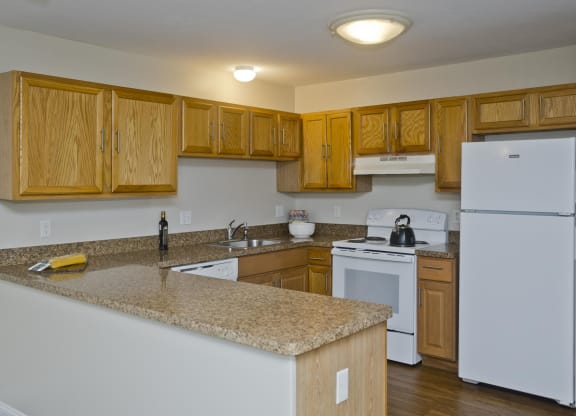 a kitchen with white appliances and granite counter tops