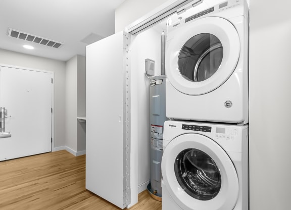 a white washer and dryer in a white laundry room with a door at 1188 Lofts, Connecticut