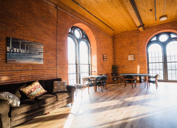 the living room with large windows and a couch and table at Ponemah Mills in Taftville, CT, 06380