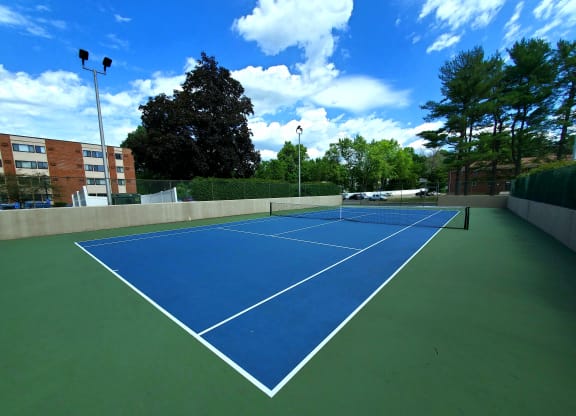 a blue and green tennis court on a sunny day at Greenfield Village Apartments, Rocky Hill, CT