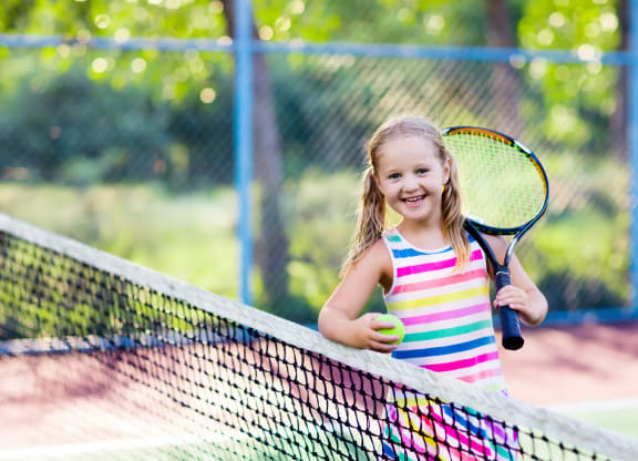 little girl playing tennis