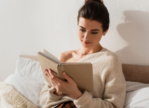 woman reading a book in bed