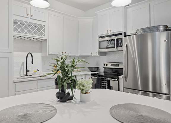 A modern kitchen with a stainless steel refrigerator and a white countertop.