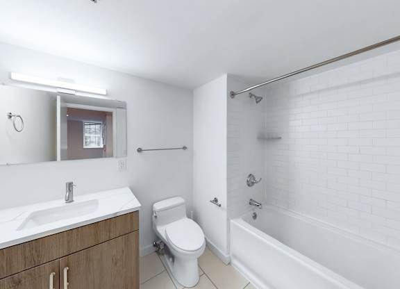 A white bathroom with a toilet, sink, and bathtub.
