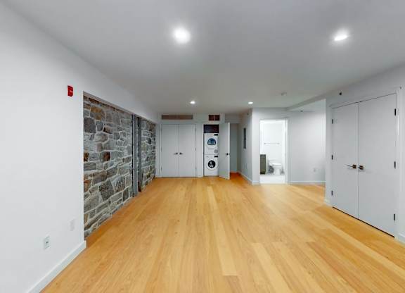 A long hallway with wooden floors and white walls.