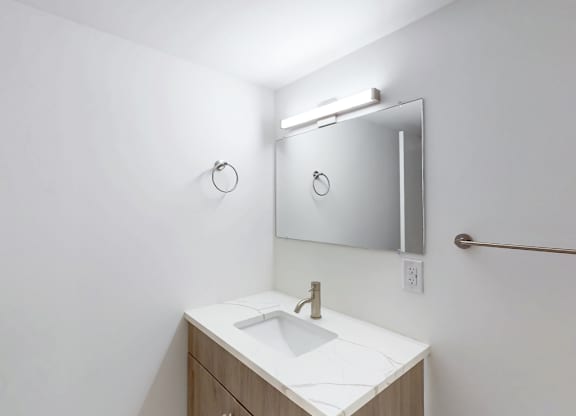 A bathroom with a white sink and a mirror above it.