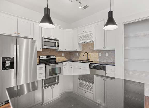 A modern kitchen with stainless steel appliances and white cabinets.
