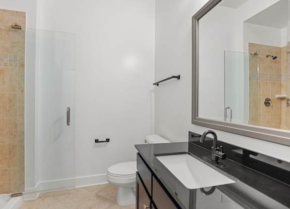 A bathroom with a toilet, sink, and shower.