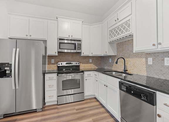 A kitchen with white cabinets and stainless steel appliances.