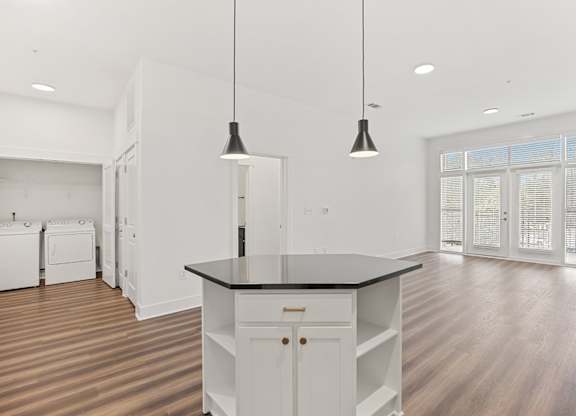 A kitchen with a black countertop and white cabinets.
