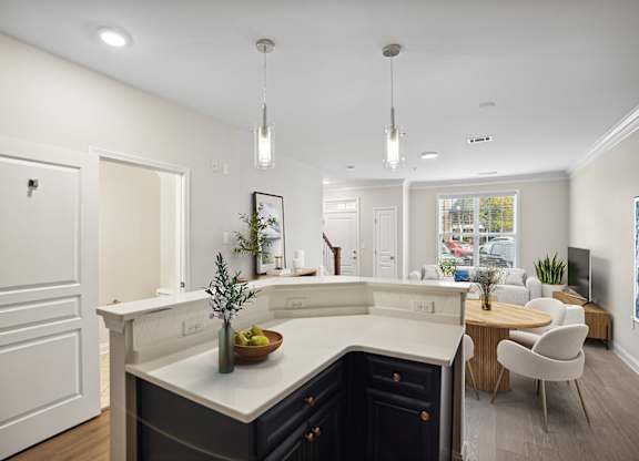 A modern kitchen with a dark blue counter and white cabinets.