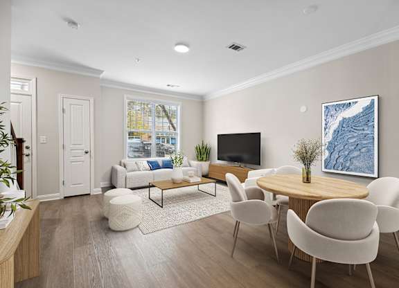 A living room with a white couch, a wooden coffee table, and a large painting on the wall.
