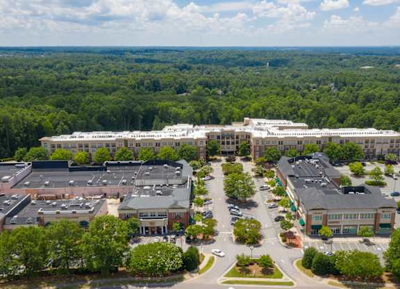 A large building complex with a parking lot in front.