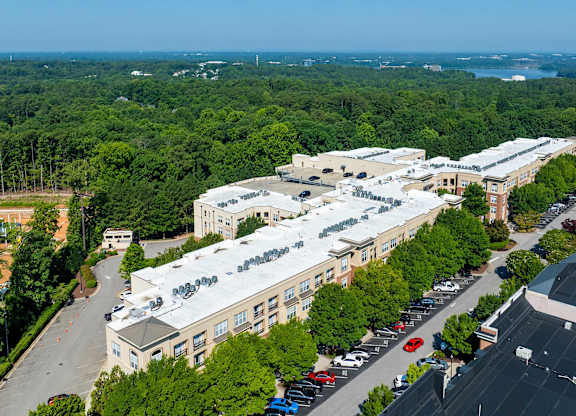 A large white building with a parking lot in front of it.