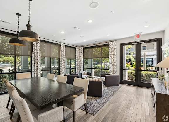 A dining room with a large table and chairs.