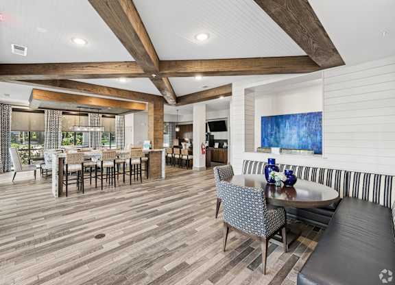 A large room with a wooden floor and a long table with chairs.