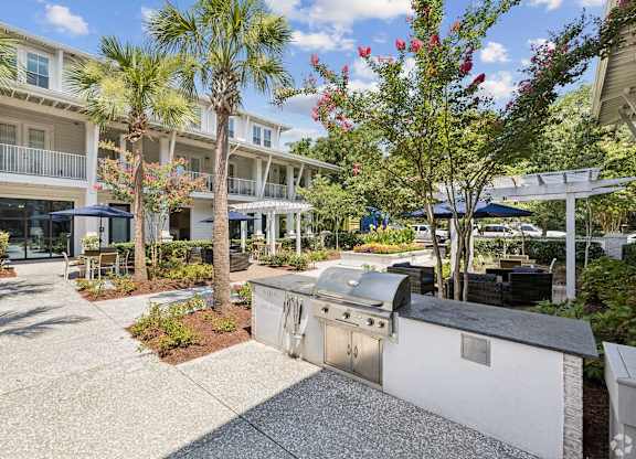 A sunny day at a residential complex with a BBQ grill in the foreground.