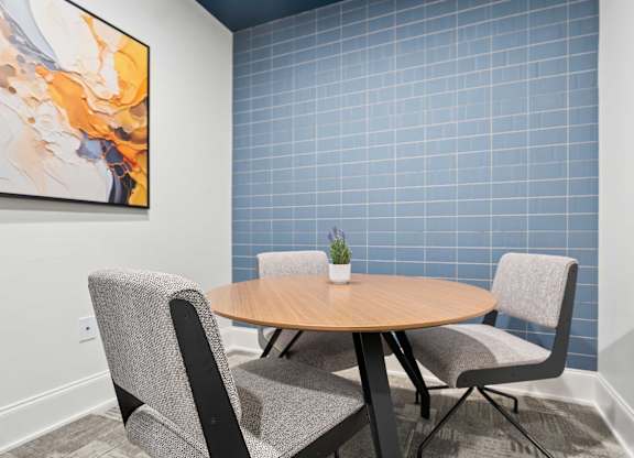 A round table with two chairs and a plant on it.