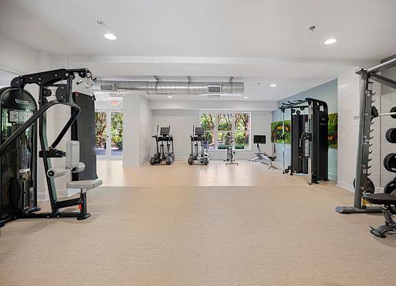 A spacious gym with various exercise machines and equipment.
