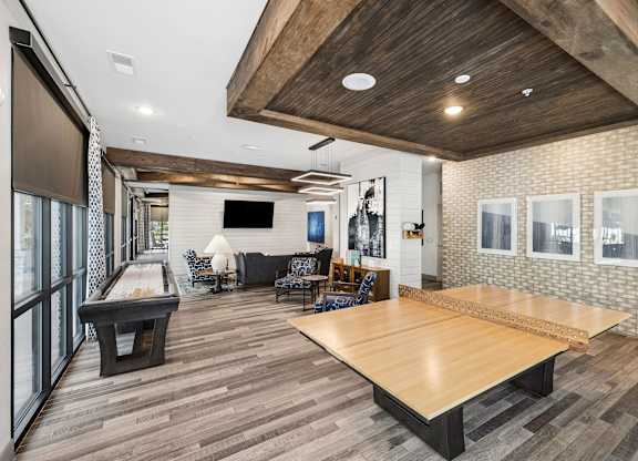 A room with a pool table and a shiny wooden floor.