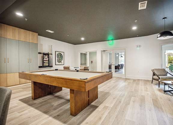 A room with a pool table and a chair.