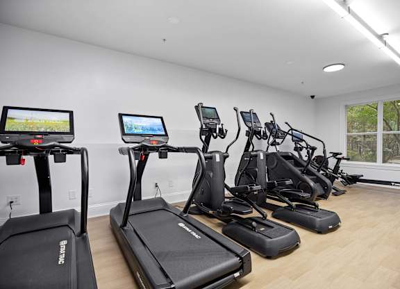 A gym with treadmills and elliptical machines.