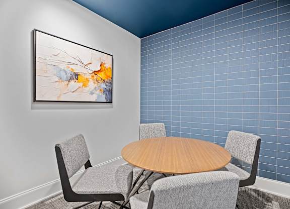 A modern dining room with a round table and grey chairs.