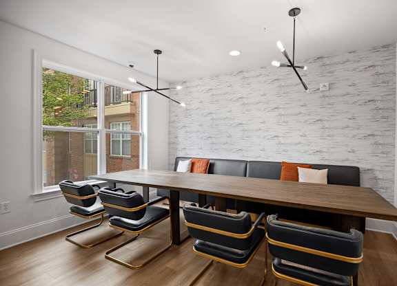 A white brick wall with a wooden table and chairs in front of it.