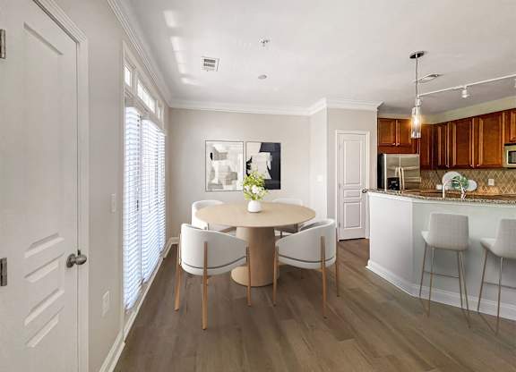A dining room with a round table and chairs.