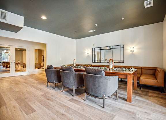 A modern dining room with a long table and grey chairs.