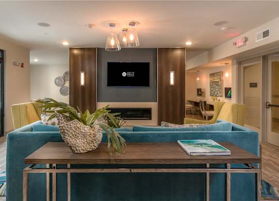 A living room with a blue couch and a wooden coffee table.