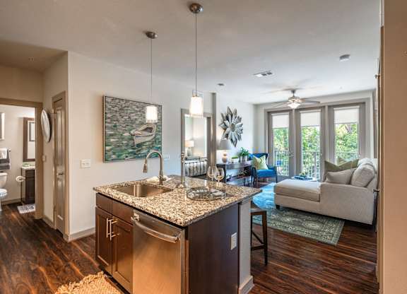 A kitchen with a granite countertop and stainless steel appliances.