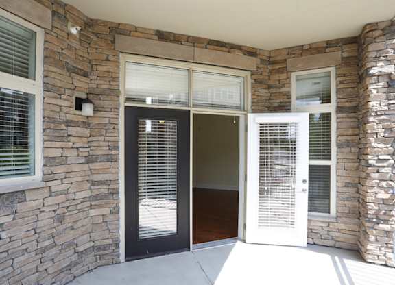 A stone wall with a black door and a white door.