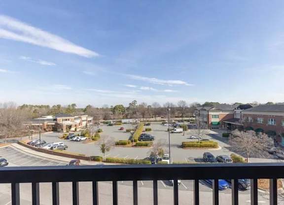 A parking lot with several cars and a building in the background.
