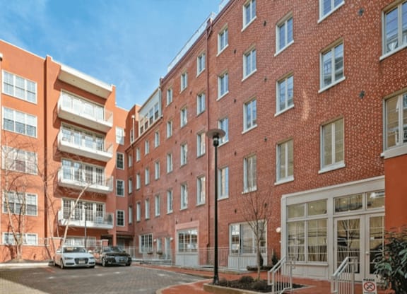 A red brick building with a white car parked in front.