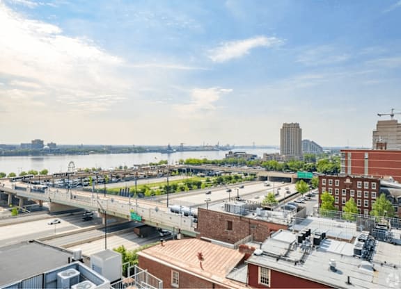 A cityscape with a river and a bridge in the background.