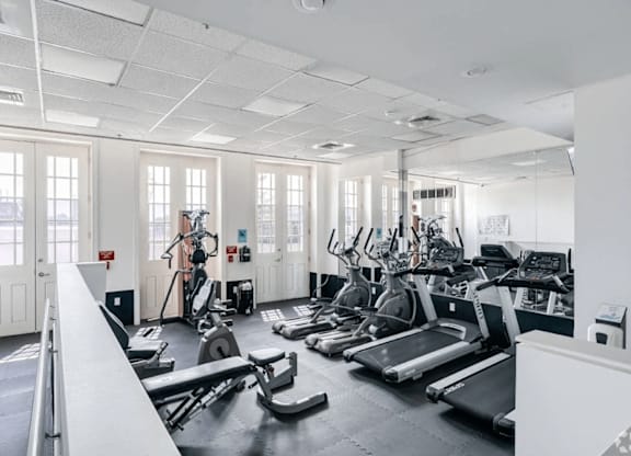A gym with treadmills, exercise bikes, and other equipment.