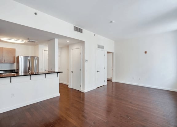 A spacious room with wooden floors and white walls.