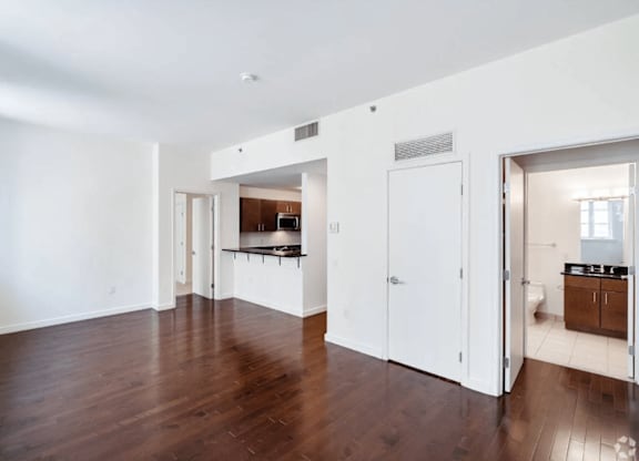 A large empty room with wooden floors and white walls.