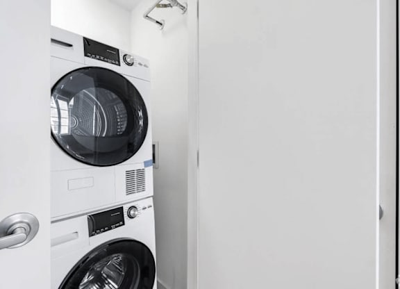 A white front load washing machine with a black door and control panel.