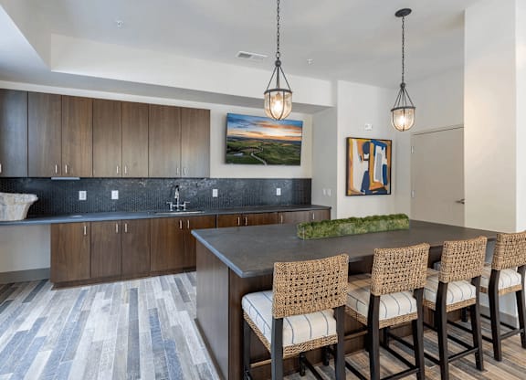A kitchen with a large island and chairs.