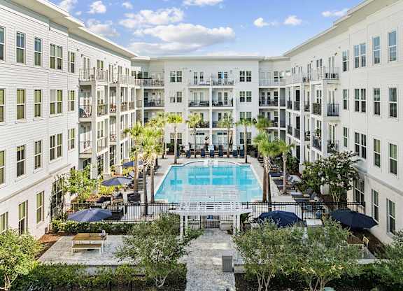 A large white building with a pool in the middle of the courtyard.