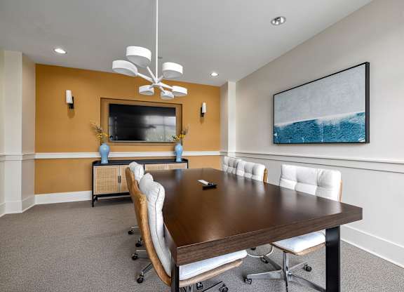 A conference room with a long table and chairs.