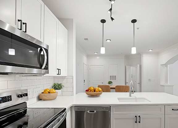 A modern kitchen with a stainless steel oven and a white countertop.