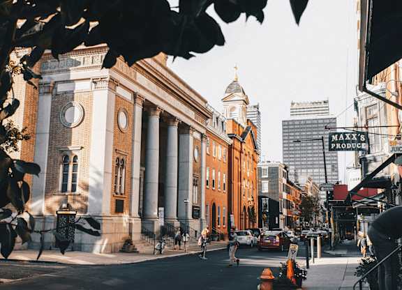 A street view of a building with a clock tower and a sign that says