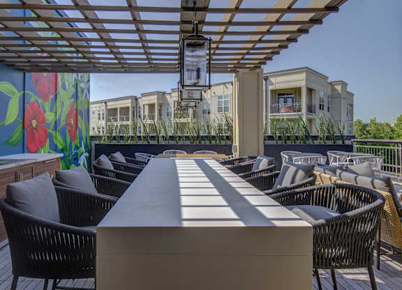 A patio with a table and chairs under a roof.